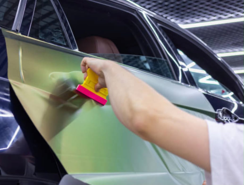 Applying film to glazing with a squeegee